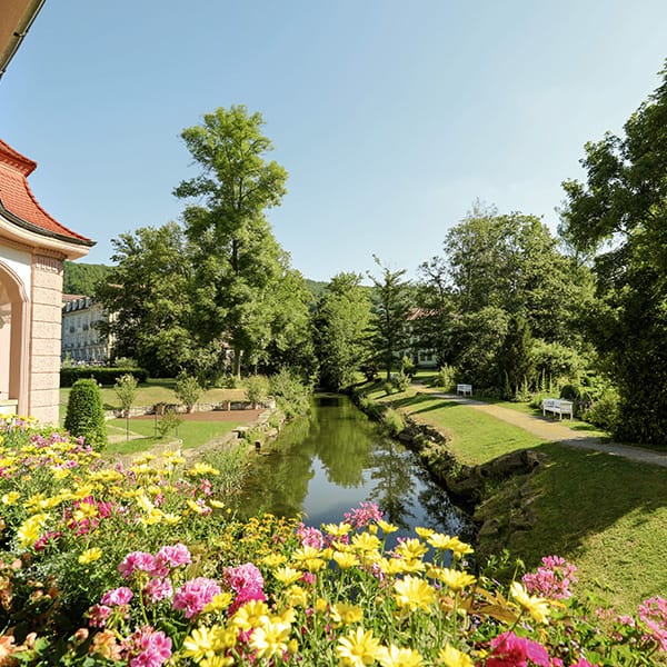 Barockes Gebäude, Bach und Blumenrabatte